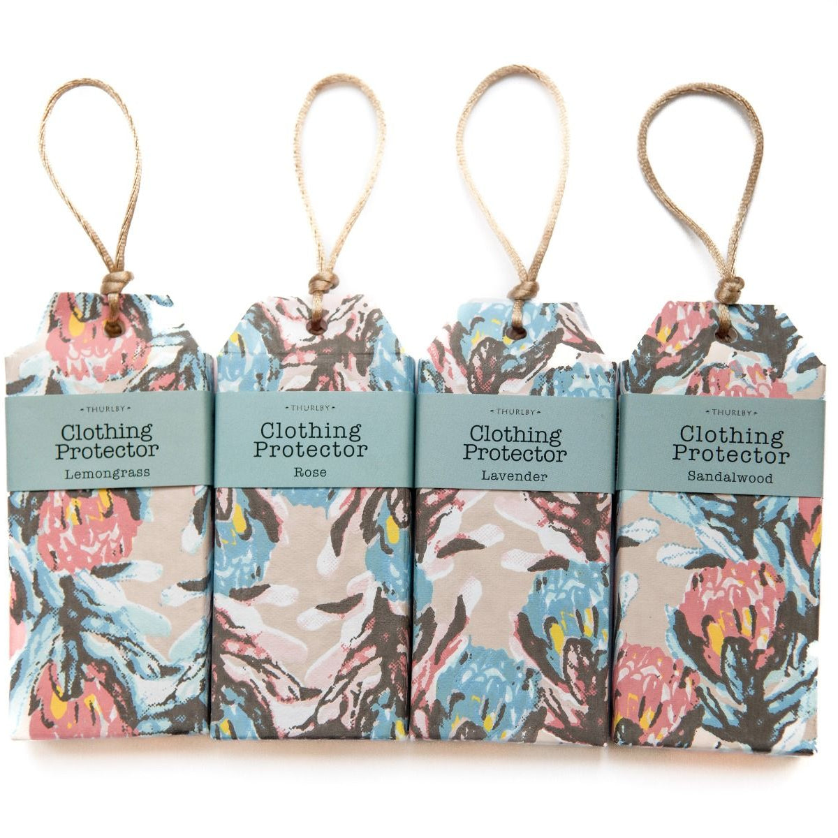 Four hanging fabric tags for clothing protection, each with a different scent and a floral print on a beige background. The tags have a light blue-green label band with text including 'UNIQUELY', 'Clothing Protector', and scents like Lemongrass, Rose, Lavender, and Sandalwood.